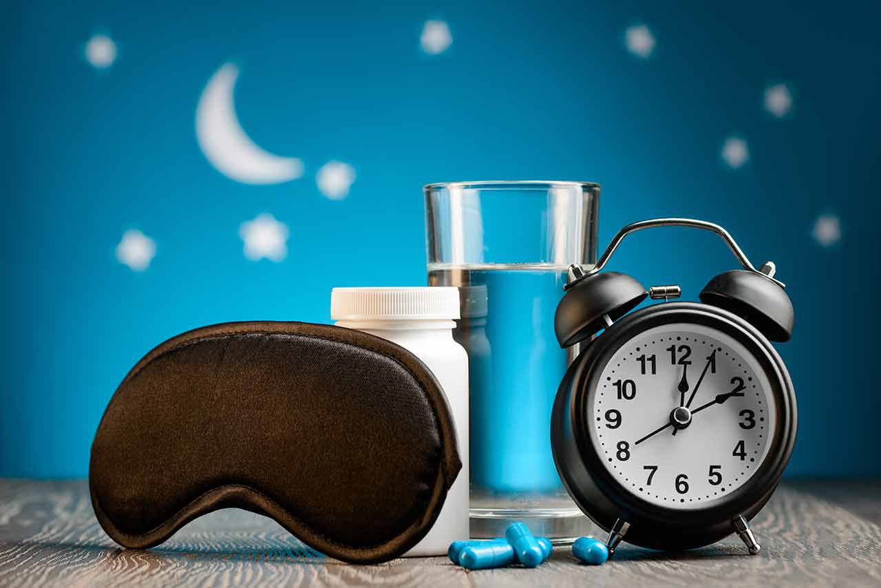 Melatonin, sleep pills, and clock on a table
